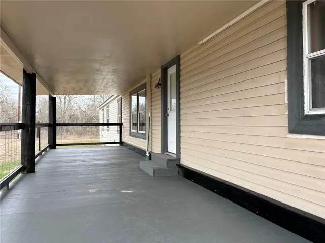 a view of a porch with wooden floor and fence