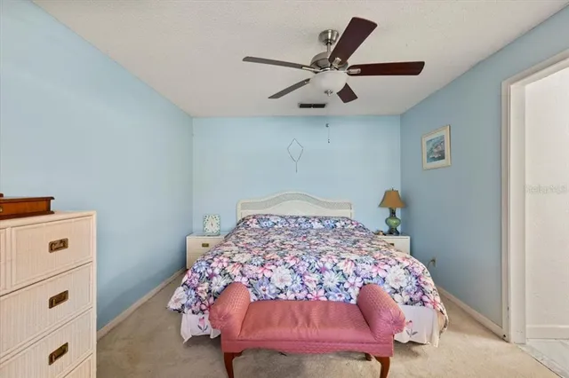 a view of a swimming pool with a bench and trees around