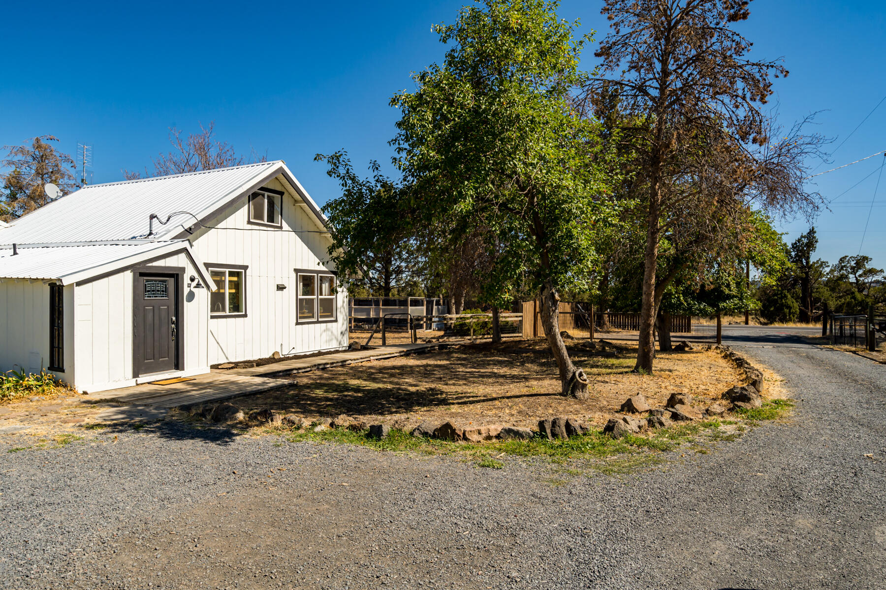 65515 Cline Falls Road Bend, OR 97703 - Photo 3 of 57 a view of a white house with a yard and sitting area