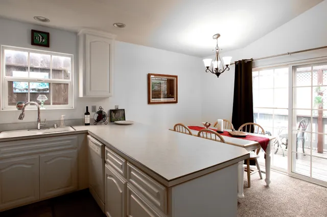 a kitchen with stainless steel appliances granite countertop a refrigerator sink and white cabinets