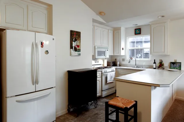 a kitchen with stainless steel appliances granite countertop a sink stove and white cabinets