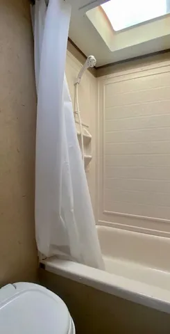 a bathroom with a toilet and a shower