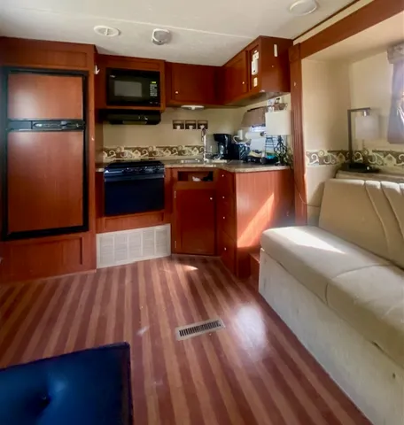 a kitchen with stainless steel appliances wooden floors and wooden cabinets