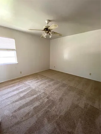 en empty room with windows and fan