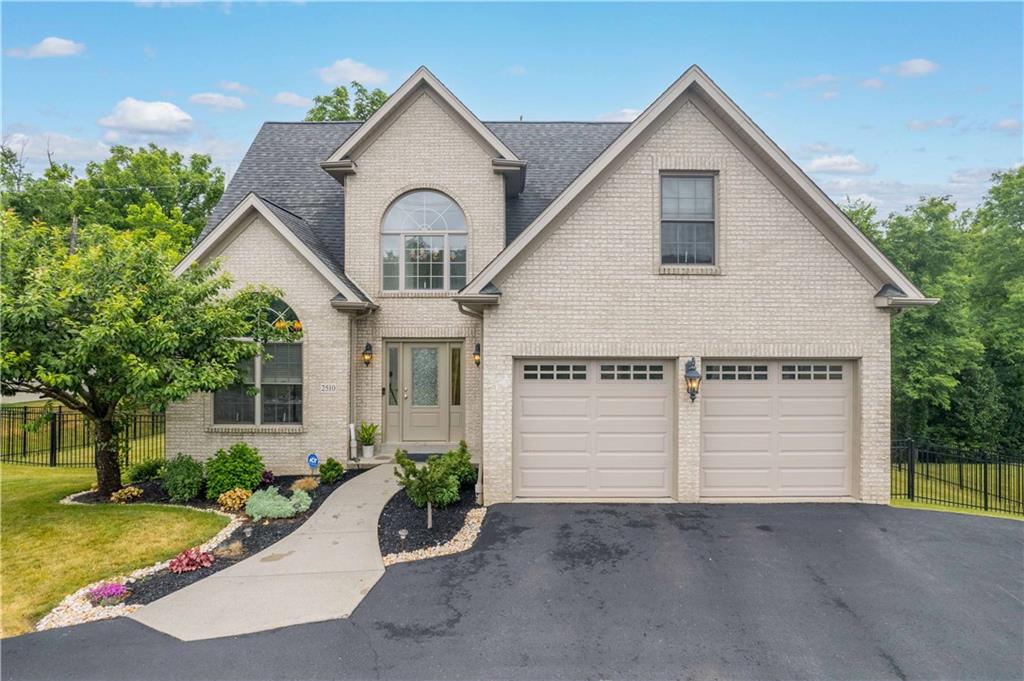 a view of a white house with a yard and potted plants