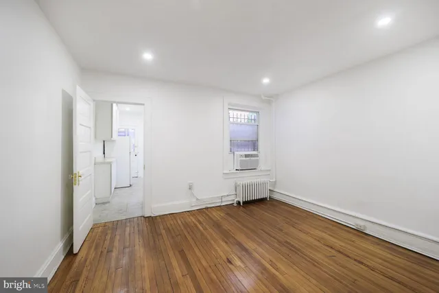 a view of empty room with wooden floor