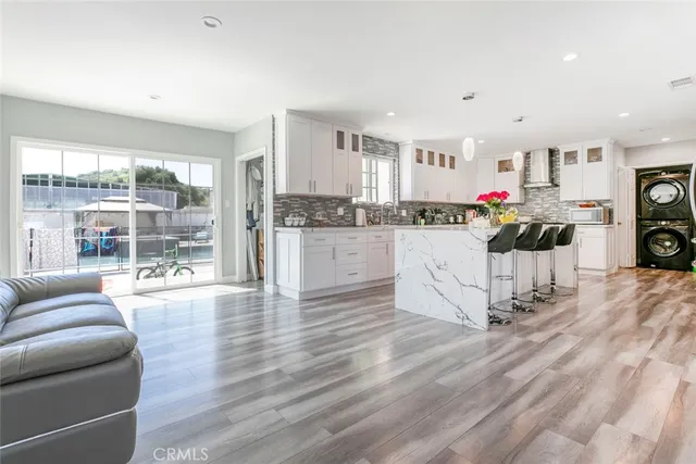 a large white kitchen with lots of counter space and stainless steel appliances