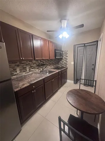 a kitchen with stainless steel appliances granite countertop a sink table and chairs