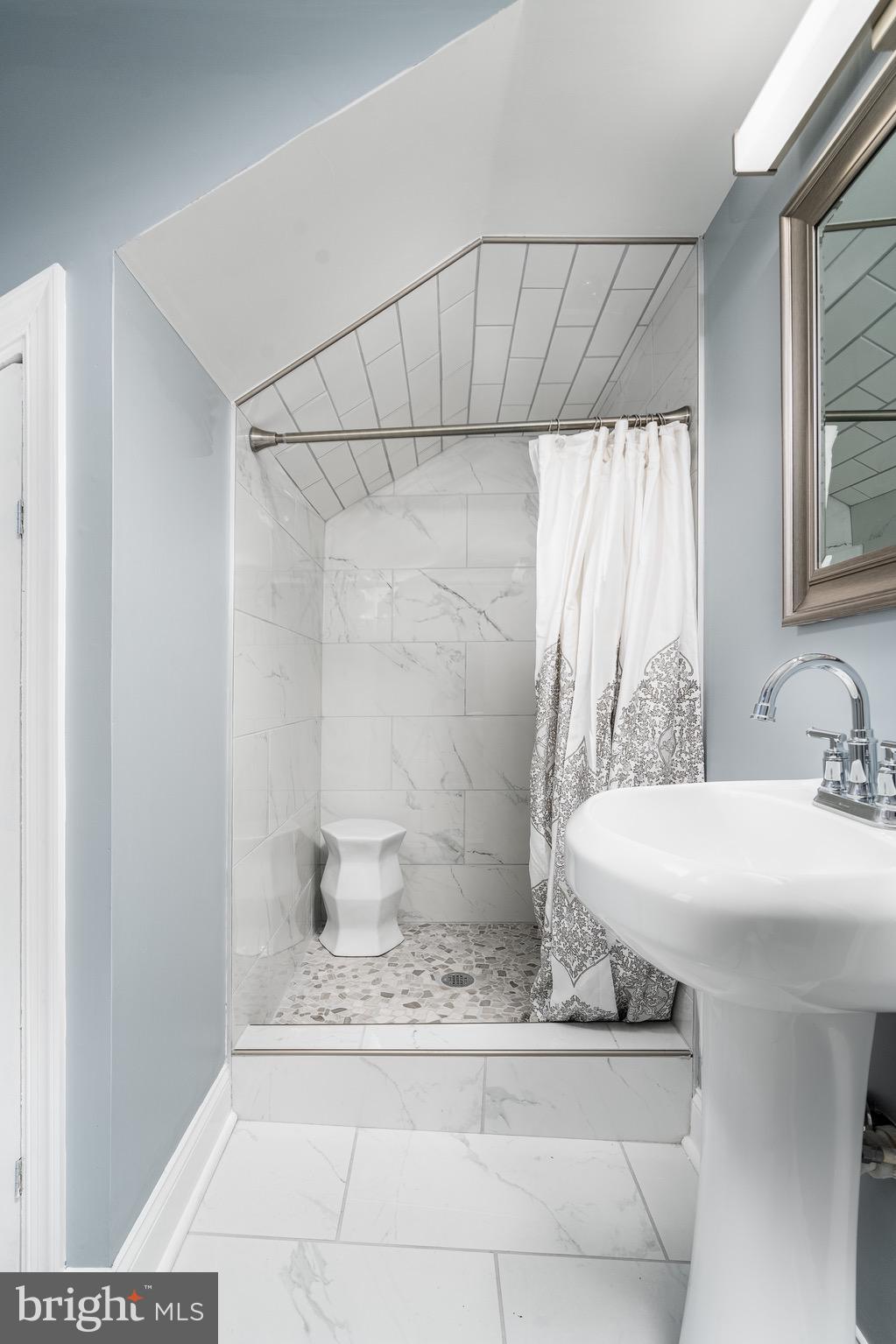 921 Eastern Avenue Baltimore, MD 21202 - Photo 18 of 23 a bathroom with a sink and a mirror