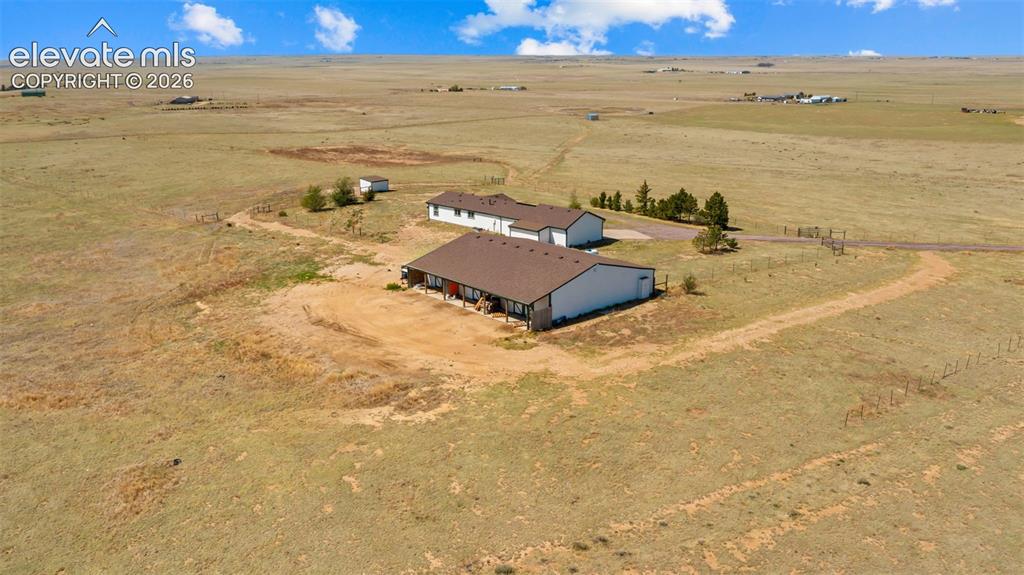 33975 Highway 94 Yoder, CO 80864 - Photo 32 of 40 Expansive property featuring a main residence with a covered porch, a separate outbuilding, and vast open land