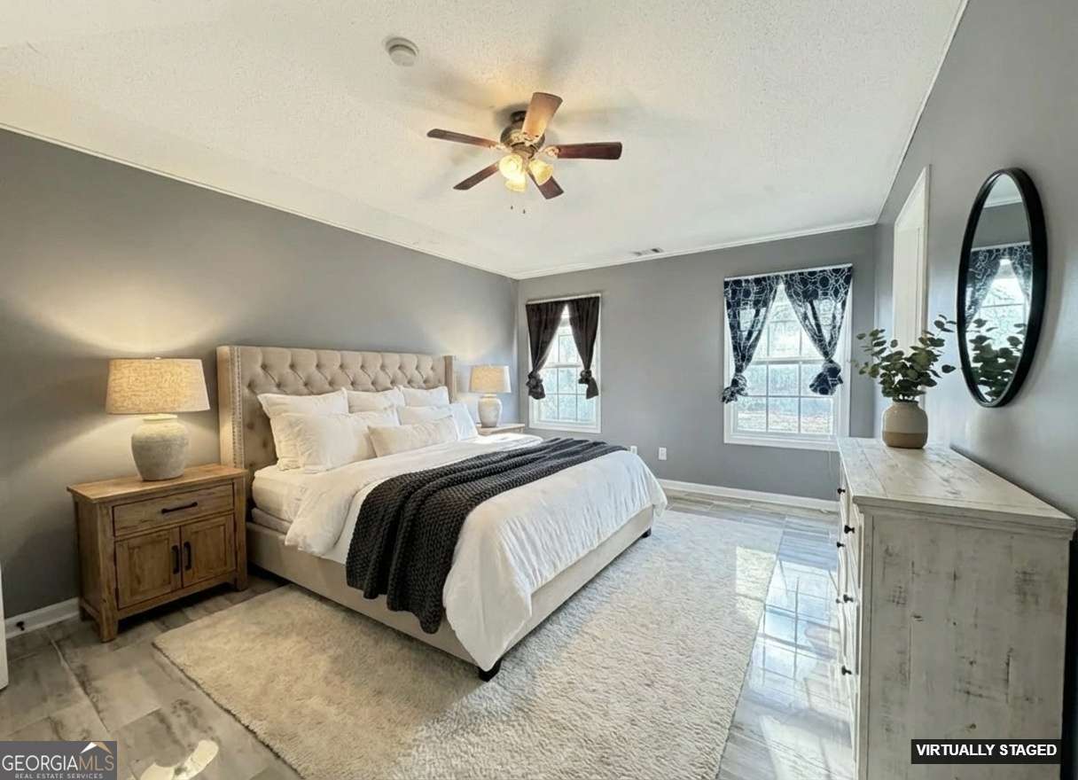 520 Redbud Lane Mount Airy, GA 30563 - Photo 14 of 26 a spacious bedroom with a bed a dresser and potted plant on the dresser