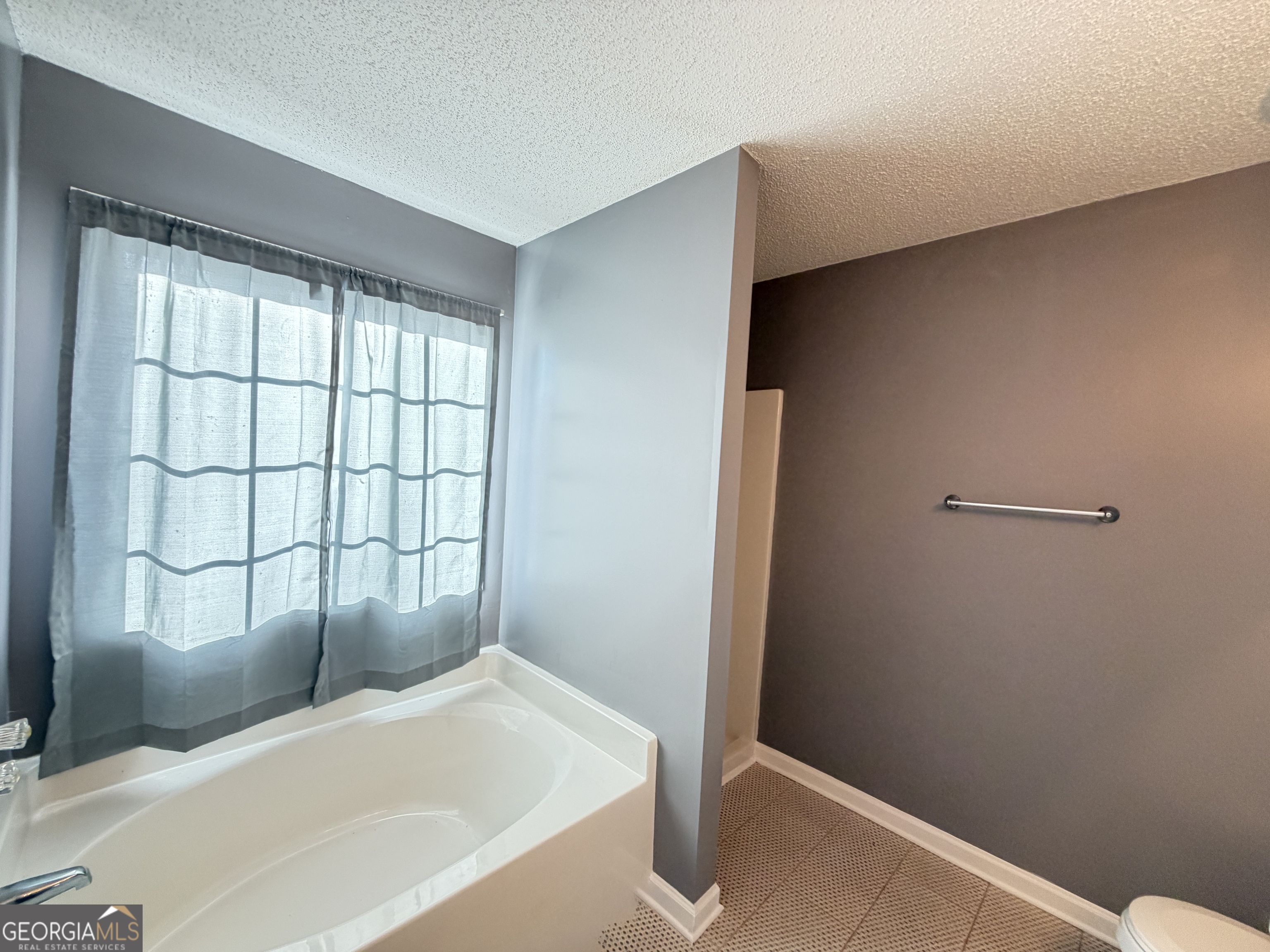 520 Redbud Lane Mount Airy, GA 30563 - Photo 16 of 26 a bathroom with a bathtub and a window