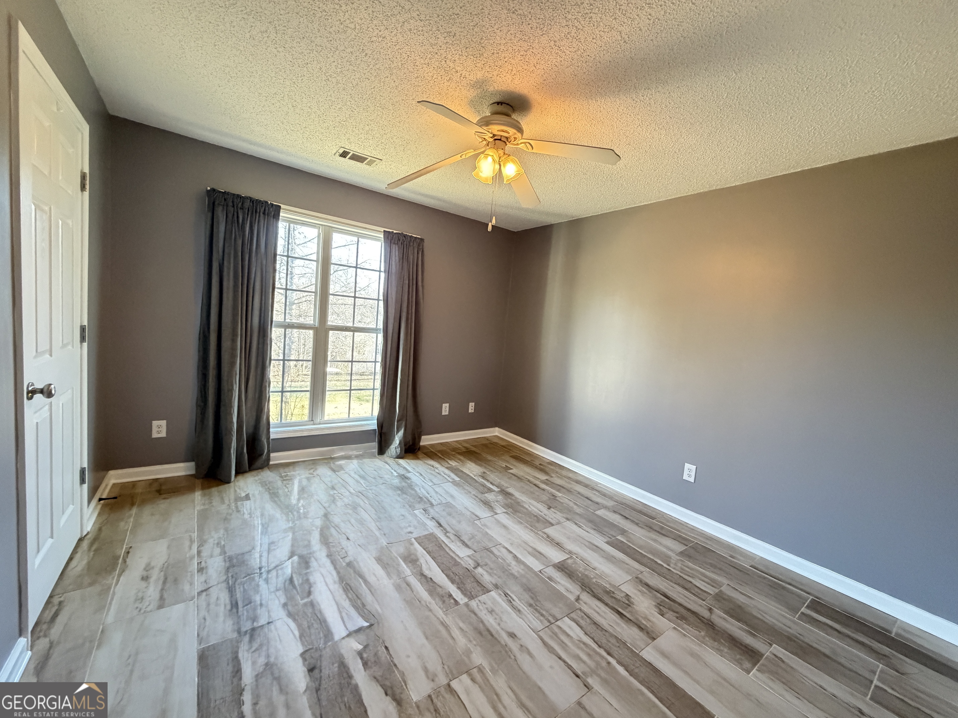 520 Redbud Lane Mount Airy, GA 30563 - Photo 21 of 26 wooden floor in an empty room with a window
