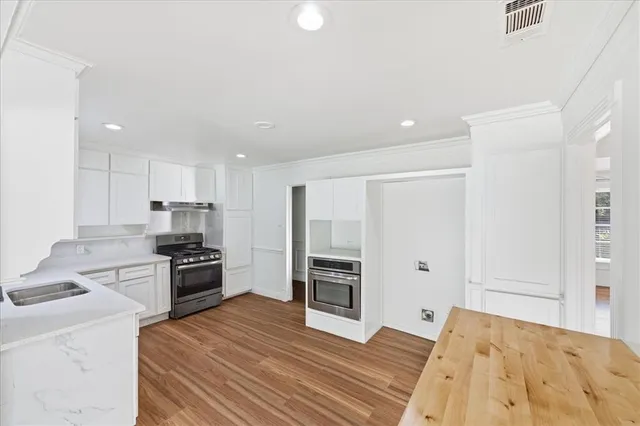 a kitchen with sink a stove and cabinets