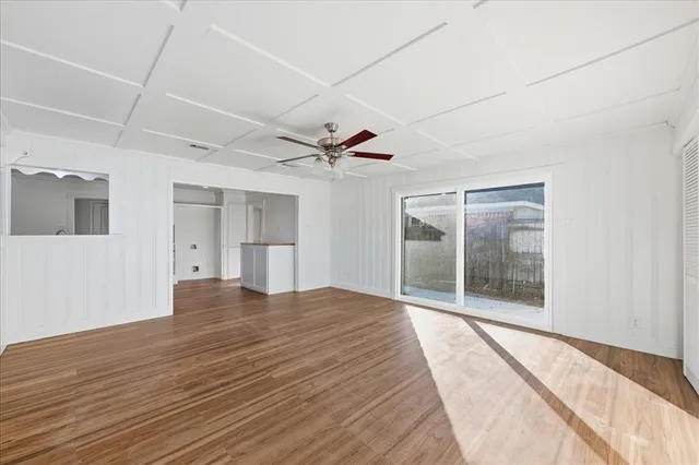 a view of a livingroom with wooden floor and a ceiling fan