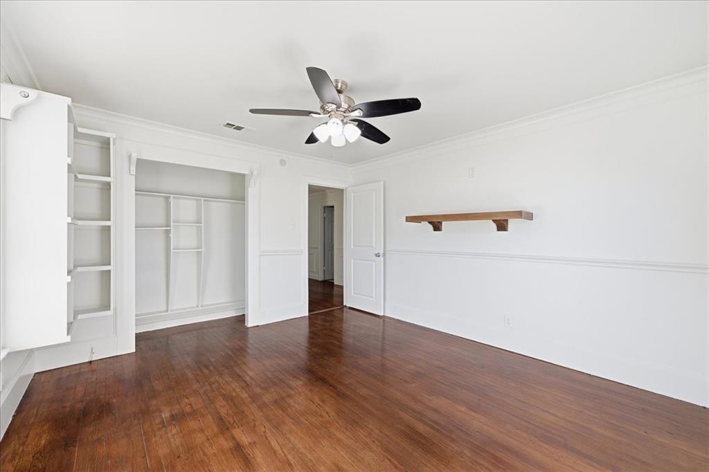 7835 Tillman Street Dallas, TX 75217 - Photo 22 of 34 an empty room with wooden floor ceiling fan and windows