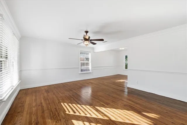 a view of a livingroom with wooden floor and a ceiling fan
