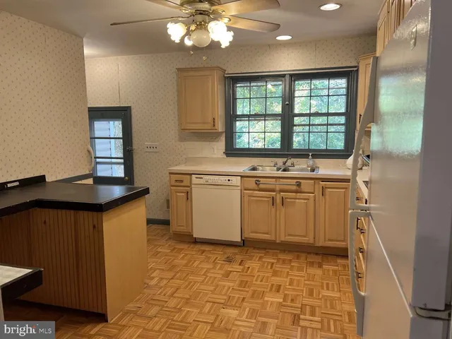 a kitchen with a stove a sink a window and cabinets
