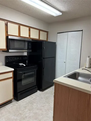 a kitchen with a refrigerator sink and microwave