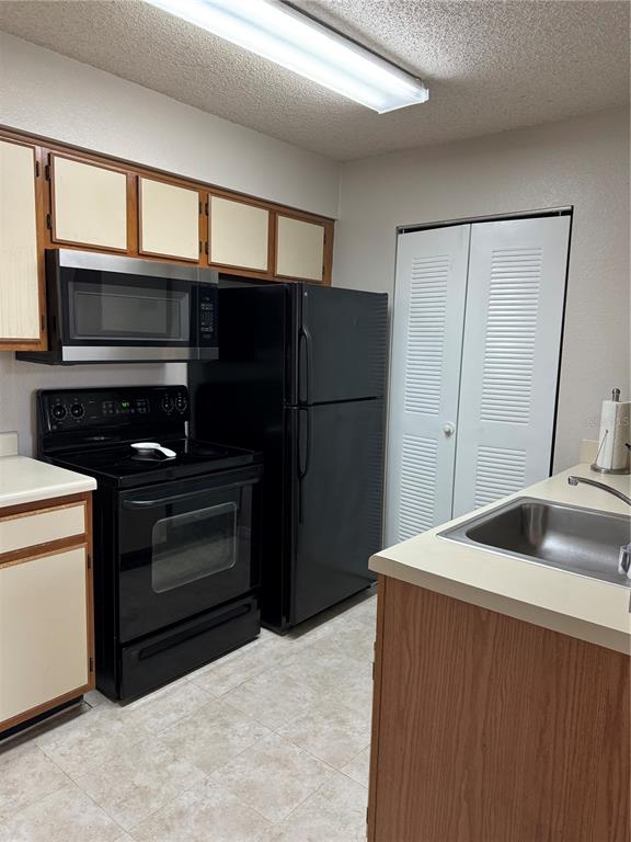 1073 South Hiawassee Road, Unit 1023 Orlando, FL 32835 - Photo 11 of 16 a kitchen with a refrigerator sink and microwave