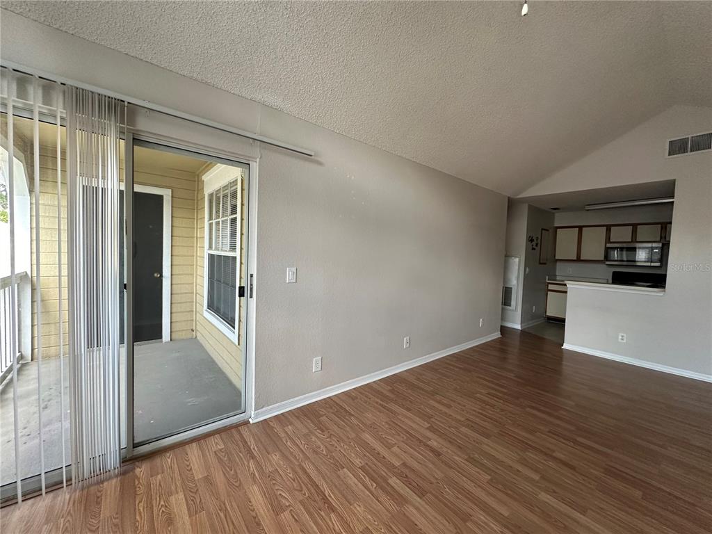 1073 South Hiawassee Road, Unit 1023 Orlando, FL 32835 - Photo 5 of 16 wooden floor in an empty room with a window