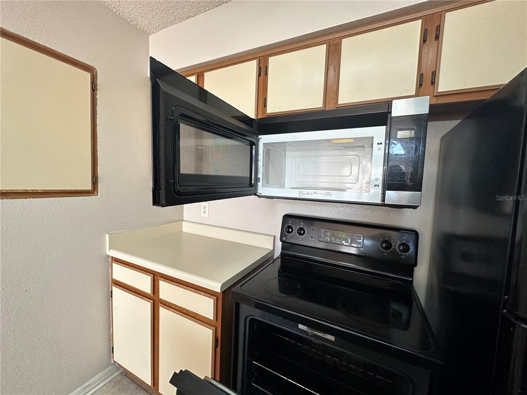 1073 South Hiawassee Road, Unit 1023 Orlando, FL 32835 - Photo 9 of 16 a kitchen with a stove and a microwave