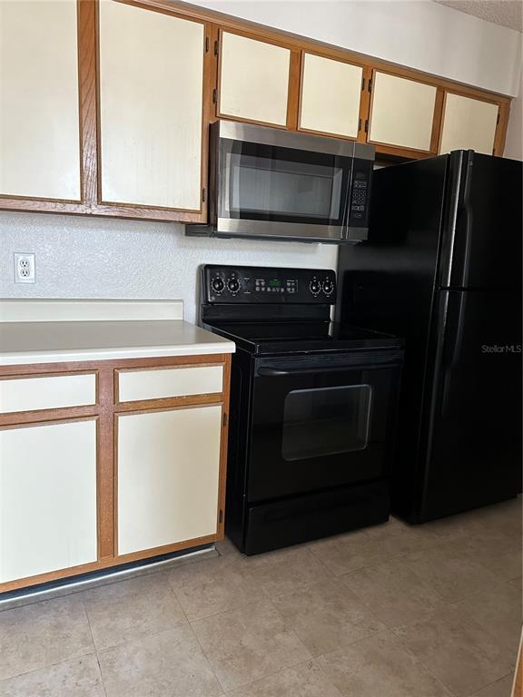 1073 South Hiawassee Road, Unit 1023 Orlando, FL 32835 - Photo 10 of 16 a kitchen with a stove and a microwave