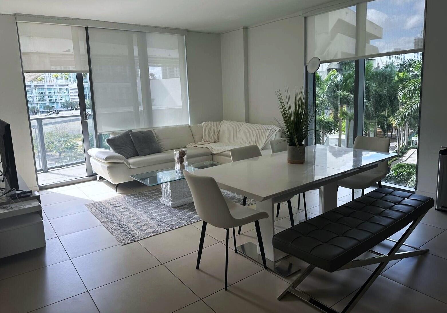 31 Southeast 6th Street, Unit 602 Miami, FL 33131 - Photo 2 of 39 a living room with furniture a large window and wooden floor