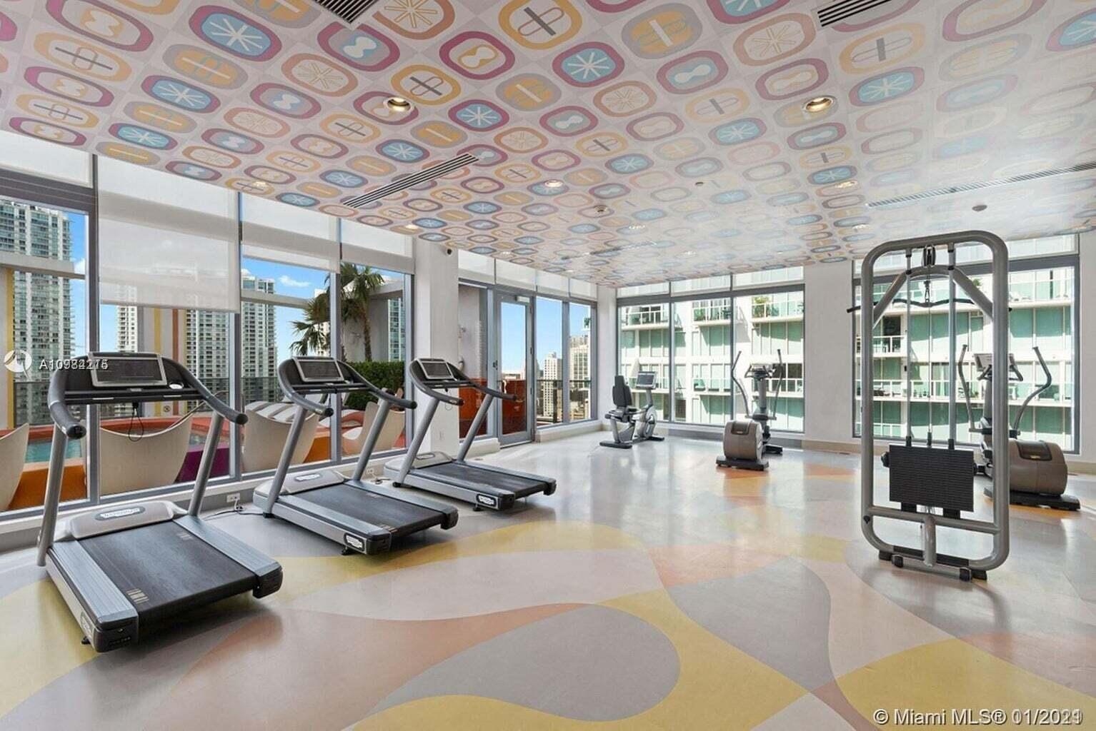 31 Southeast 6th Street, Unit 602 Miami, FL 33131 - Photo 22 of 39 a room with gym equipment and a table