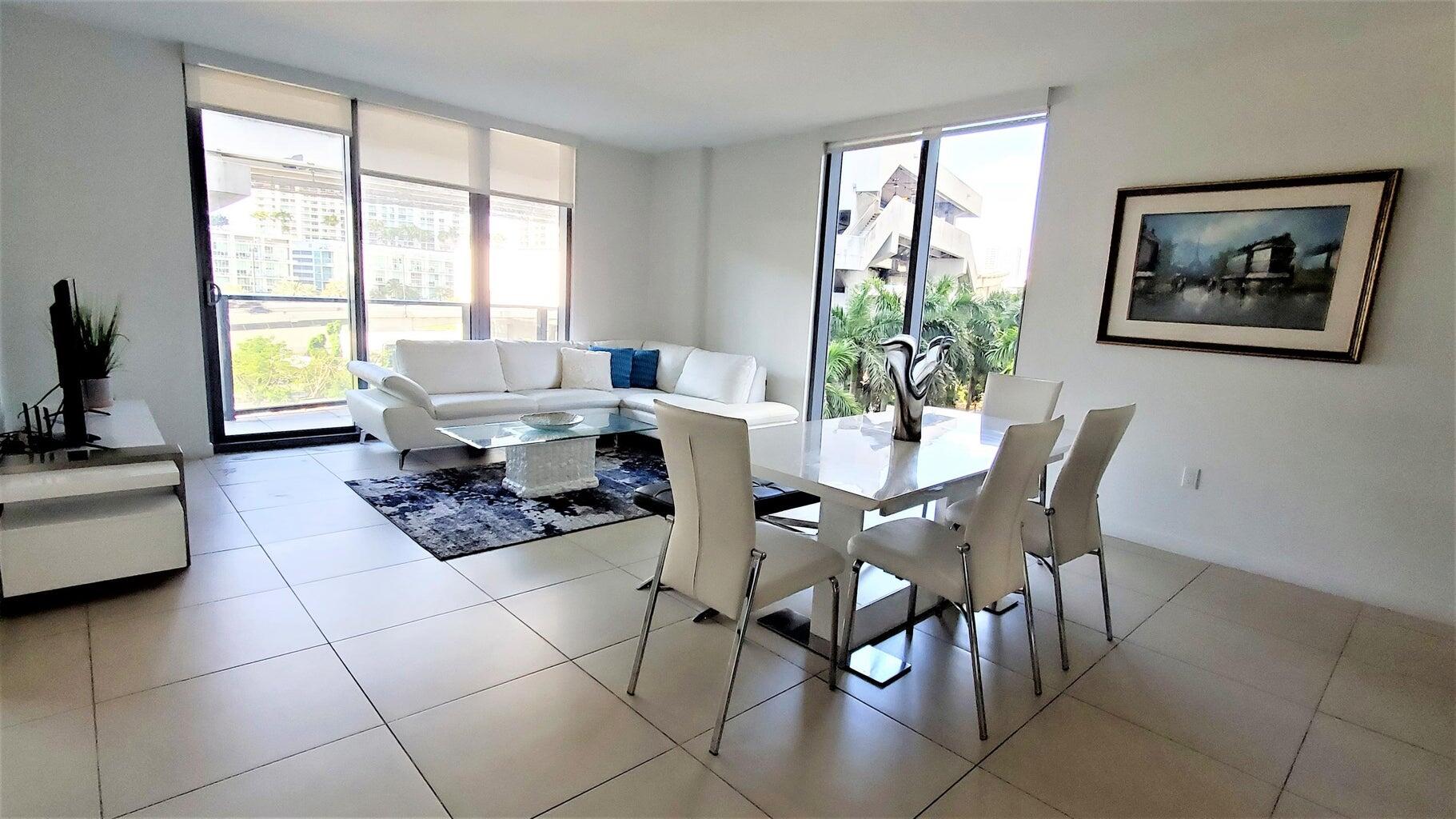 31 Southeast 6th Street, Unit 602 Miami, FL 33131 - Photo 4 of 39 a living room with furniture and floor to ceiling windows