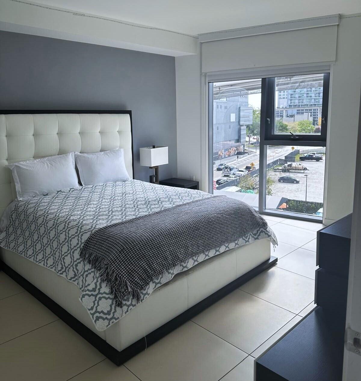 31 Southeast 6th Street, Unit 602 Miami, FL 33131 - Photo 9 of 39 a bedroom with a large bed and a window