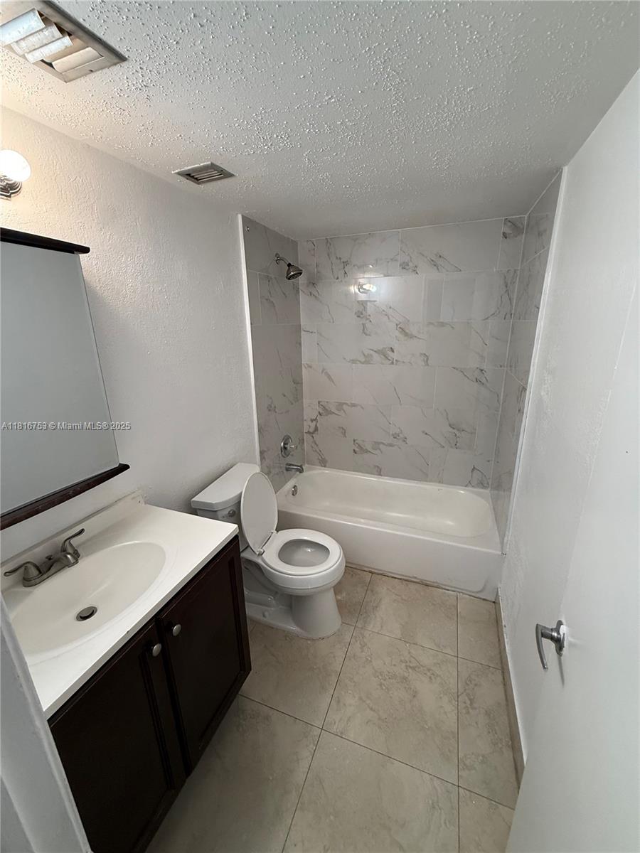 4121 Stirling Road, Unit 402 Dania Beach, FL 33314 - Photo 7 of 10 a bathroom with a sink a toilet and shower