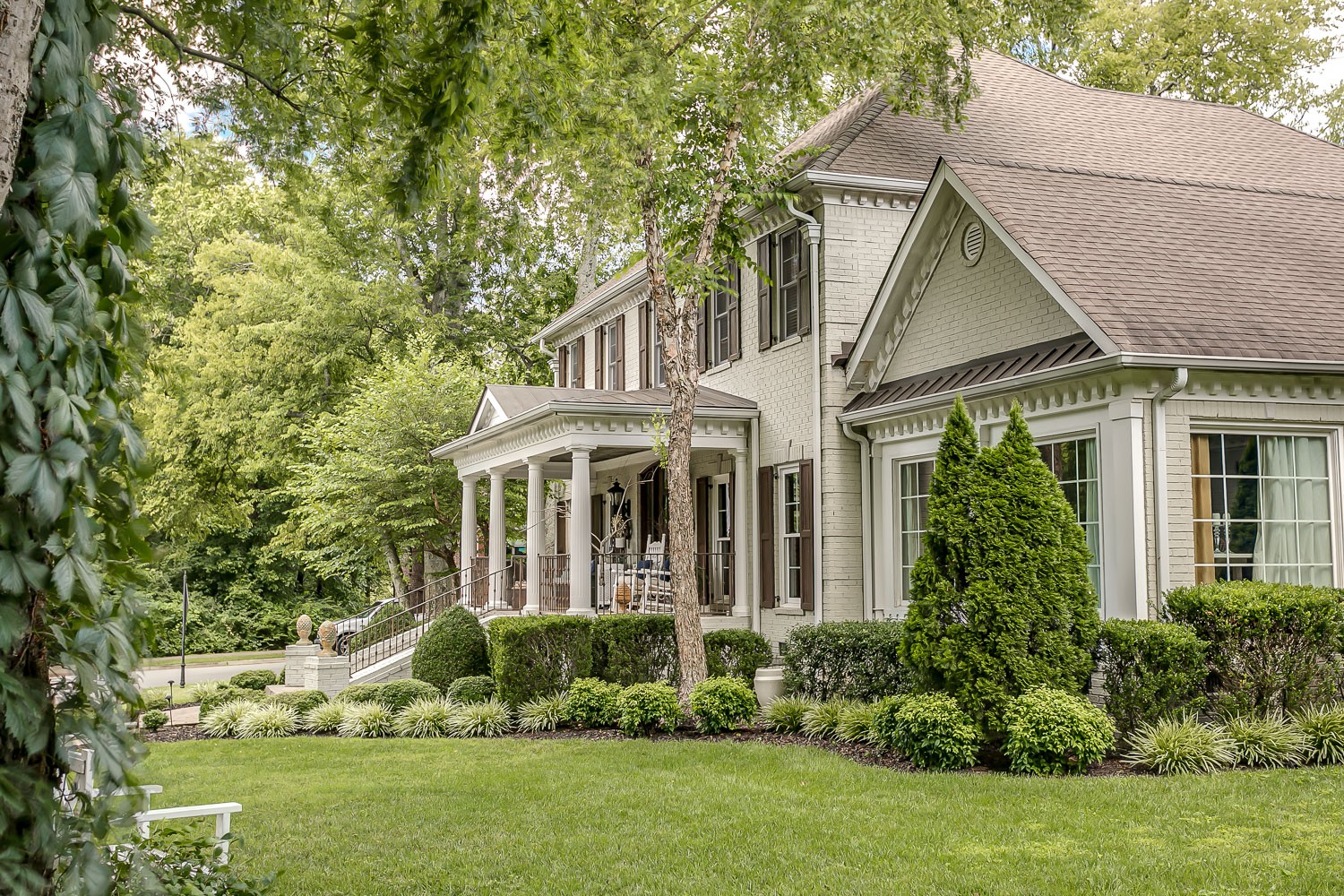 128 Deejay Drive Franklin, TN 37064 - Photo 5 of 50 a view of a white house next to a yard with plants and trees