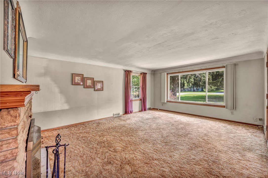 11858 Ridge Road North Royalton, OH 44133 - Photo 12 of 38 Unfurnished living room featuring a fireplace, carpet floors, and a textured ceiling