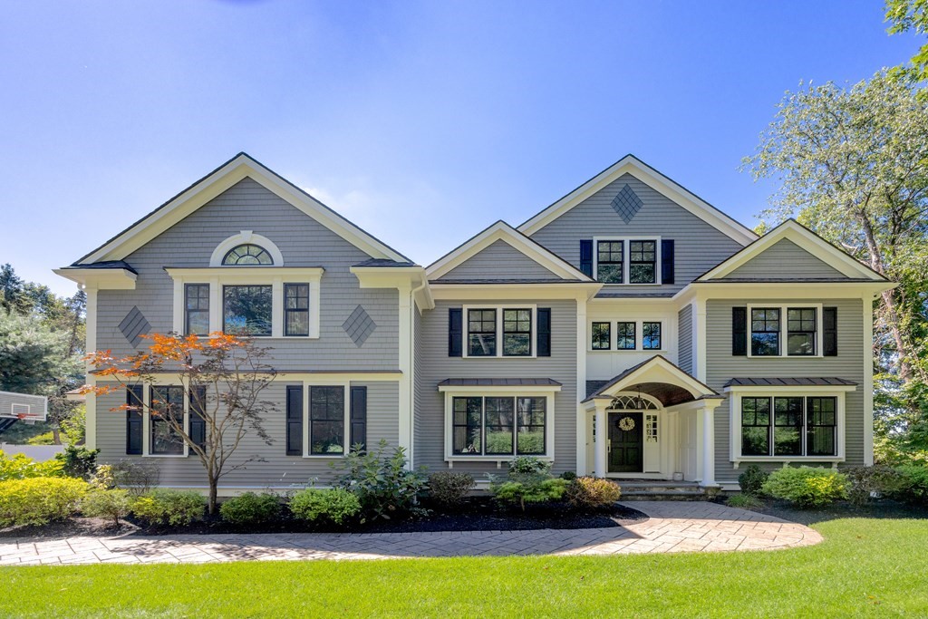 a front view of a house with a yard and trees