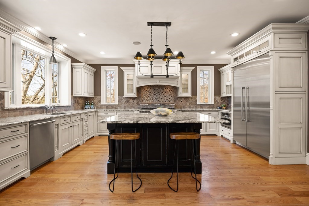 204 Cedar Street Lexington, MA 02421 - Photo 9 of 42 a kitchen with stainless steel appliances a dining table chairs stove and cabinets