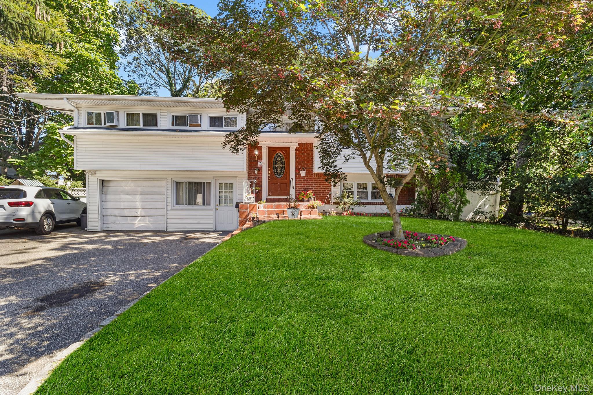 a front view of a house with a yard and trees