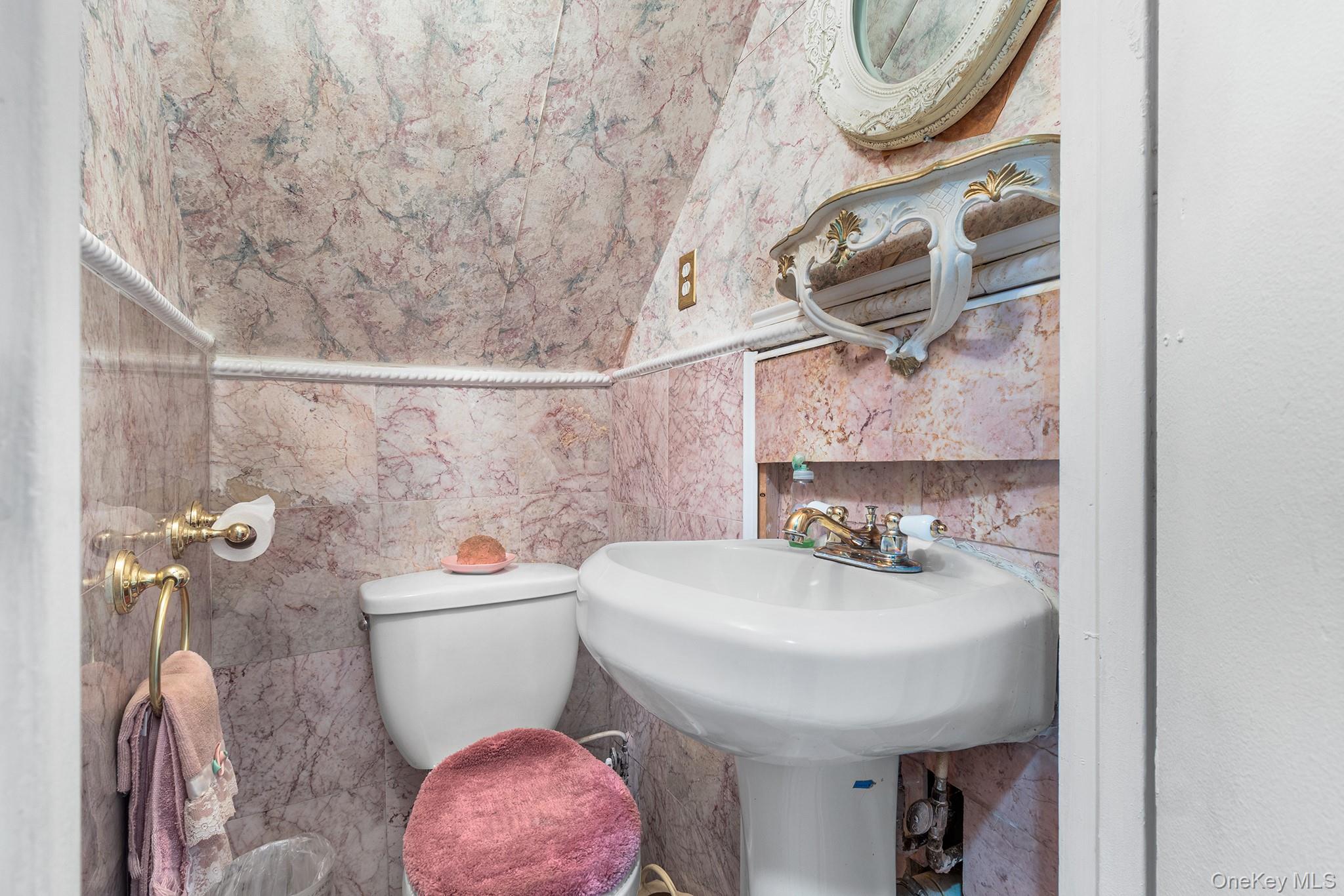31 Holbrook Road Centereach, NY 11720 - Photo 7 of 27 a bathroom with a sink a toilet and a mirror