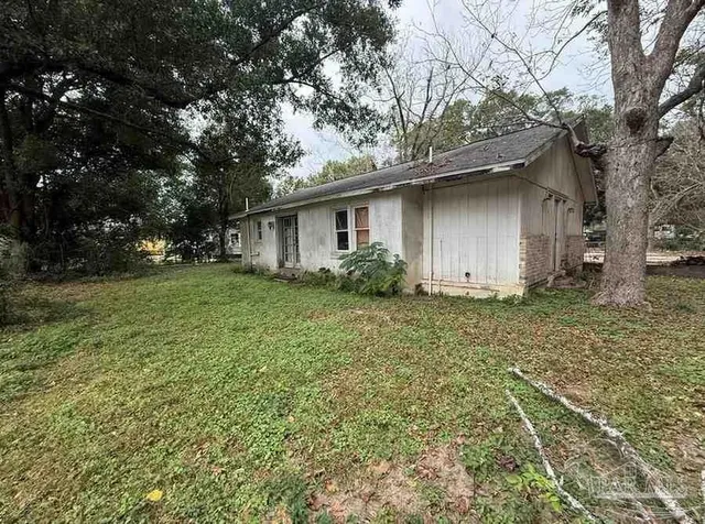a house is sitting in middle of the forest