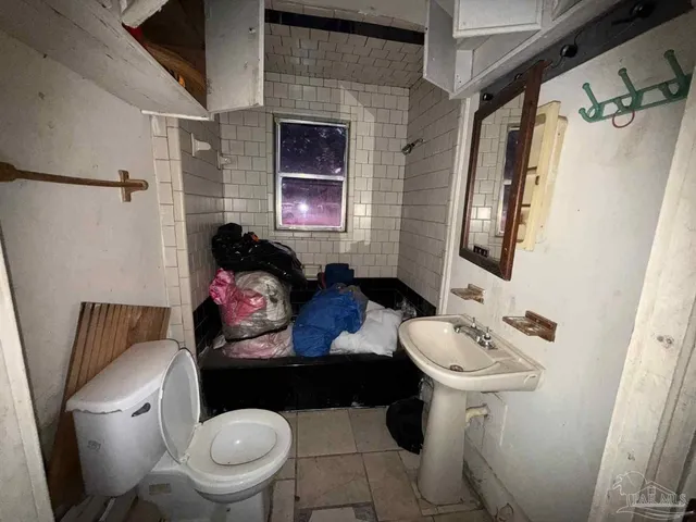a bathroom with a toilet sink and mirror