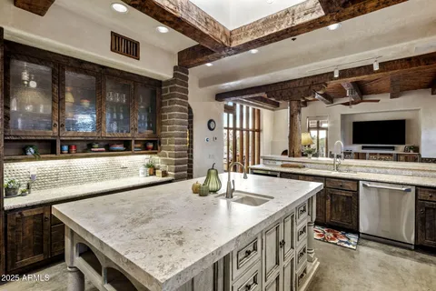 a kitchen with stainless steel appliances granite countertop a sink a stove and a wooden floors