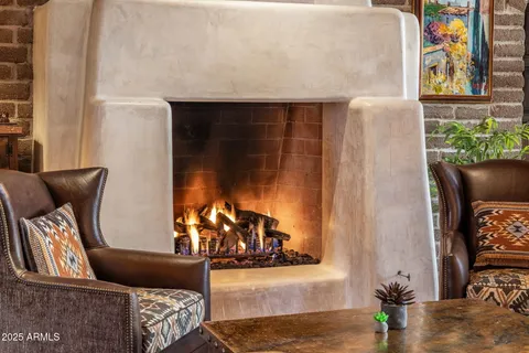 a living room with furniture a fireplace and a floor to ceiling window