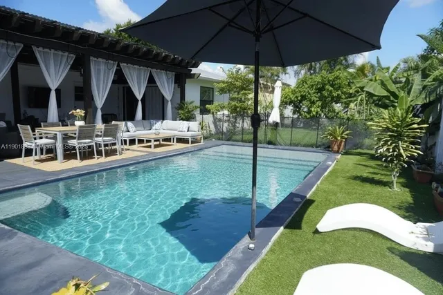a view of a house with backyard and sitting area