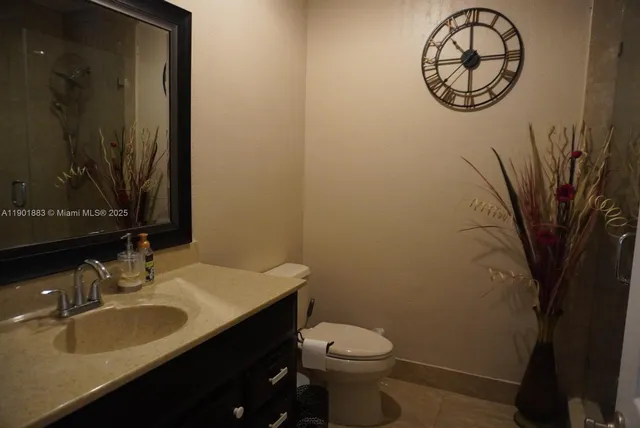 a bathroom with a sink vanity mirror and toilet