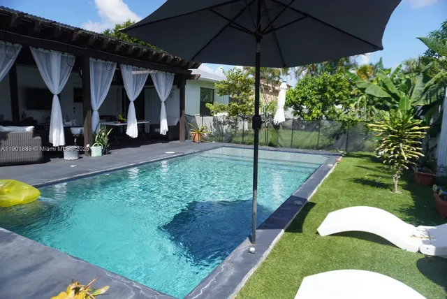 a view of a backyard with table and chairs under an umbrella