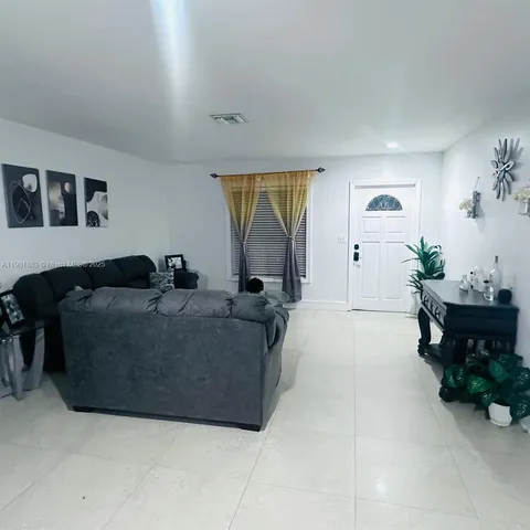 a living room with furniture and a potted plant