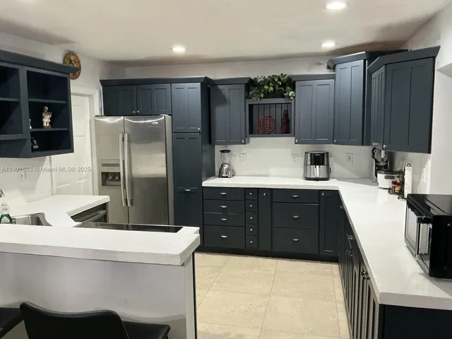 a kitchen with stainless steel appliances a refrigerator sink and microwave