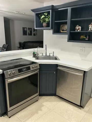 a kitchen with stainless steel appliances a sink a stove and microwave