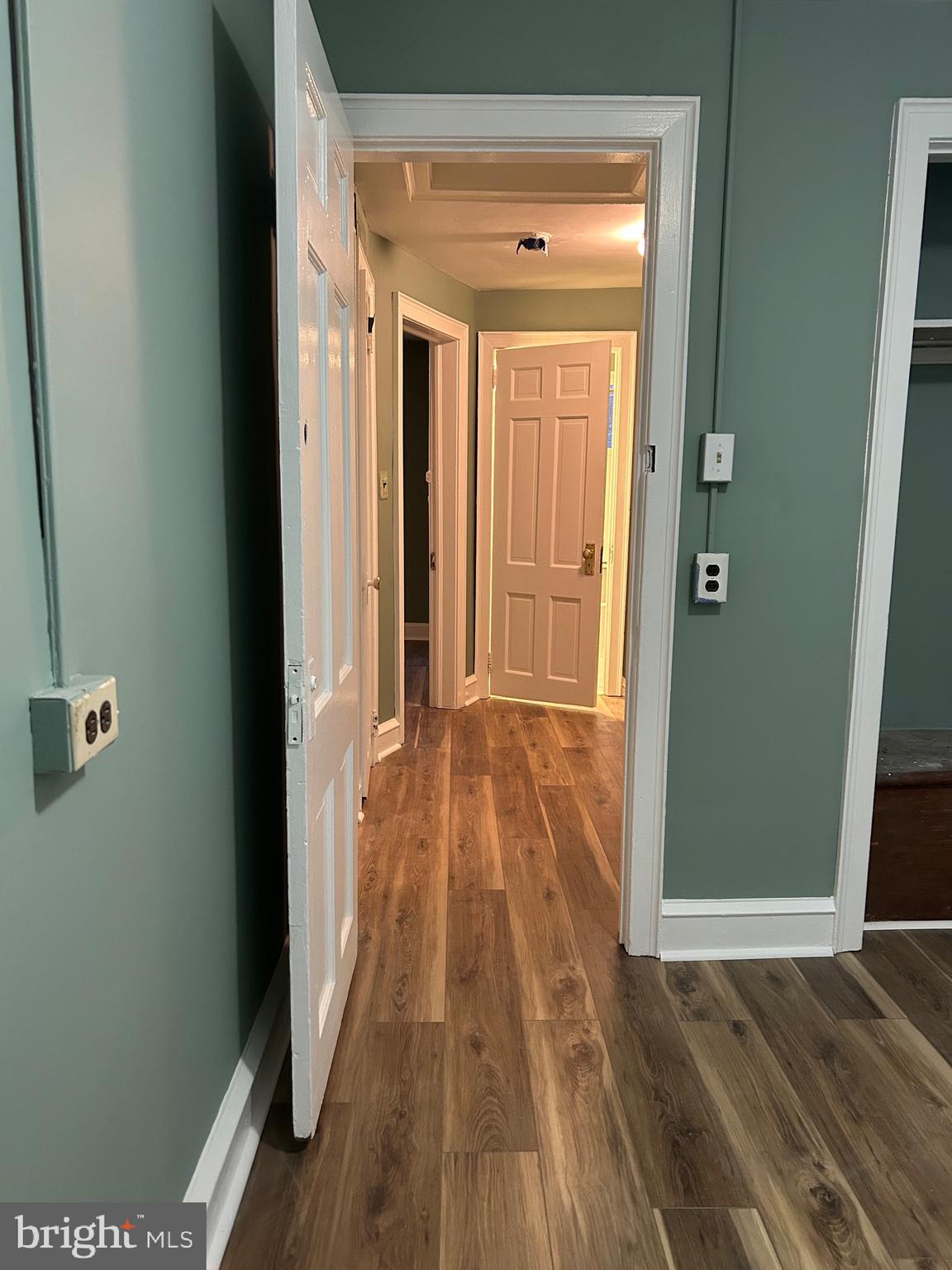 1567 Collings Road Camden, NJ 08104 - Photo 12 of 16 a view of a hallway with wooden floor and a bathroom