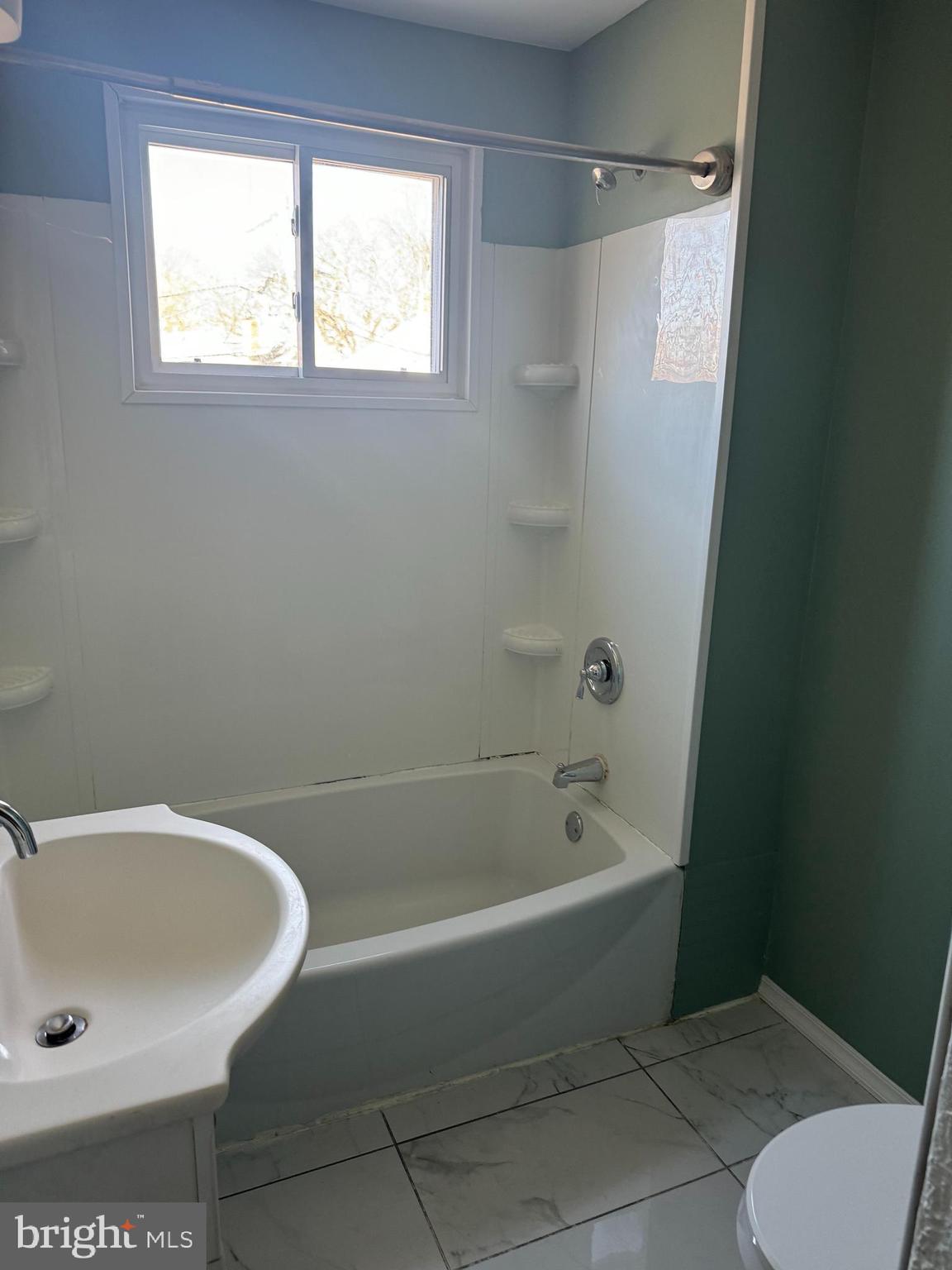 1567 Collings Road Camden, NJ 08104 - Photo 16 of 16 a bath tub sitting next to a white sink and a toilet